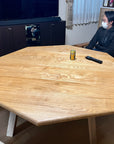 八角形テーブル。人あり。タモ無垢材。事例写真。